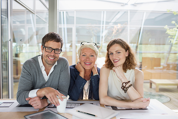 stock image of three business employees smiling at camera.