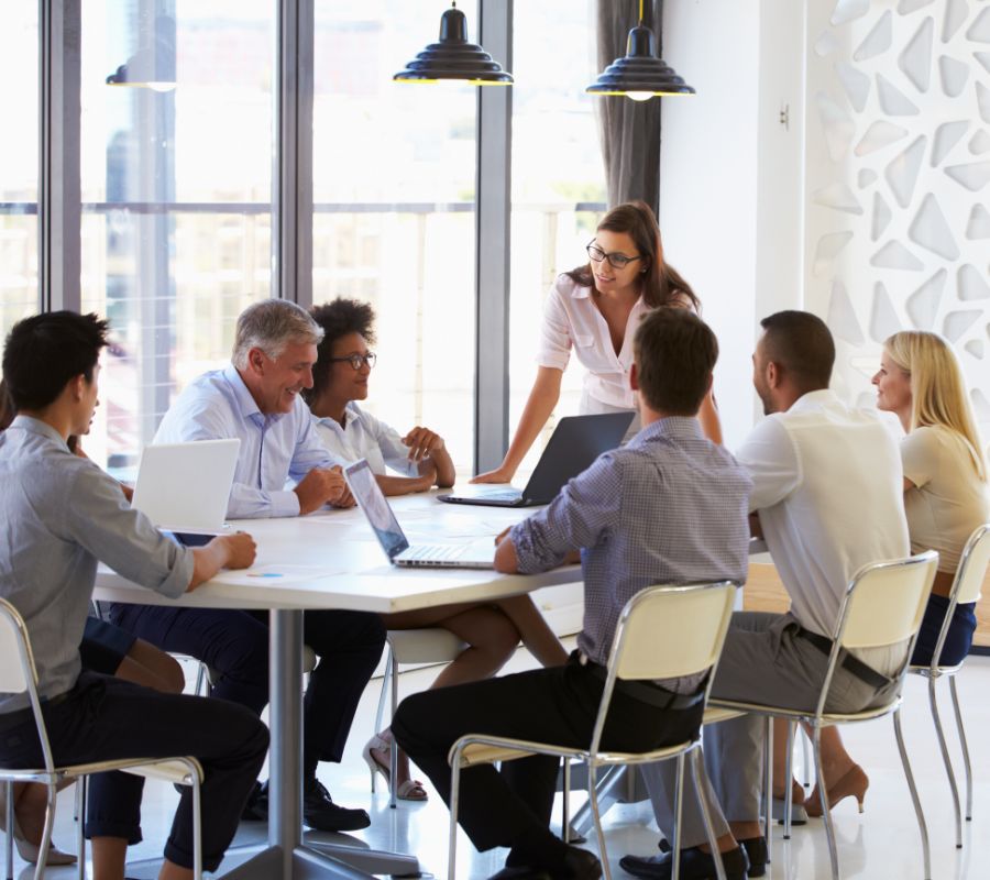 stock image of group business meeting around a conference table.