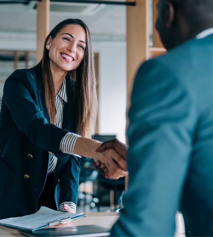 woman shaking hands with man across a table.