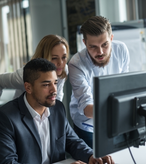 office workers gathering around a computer monitor